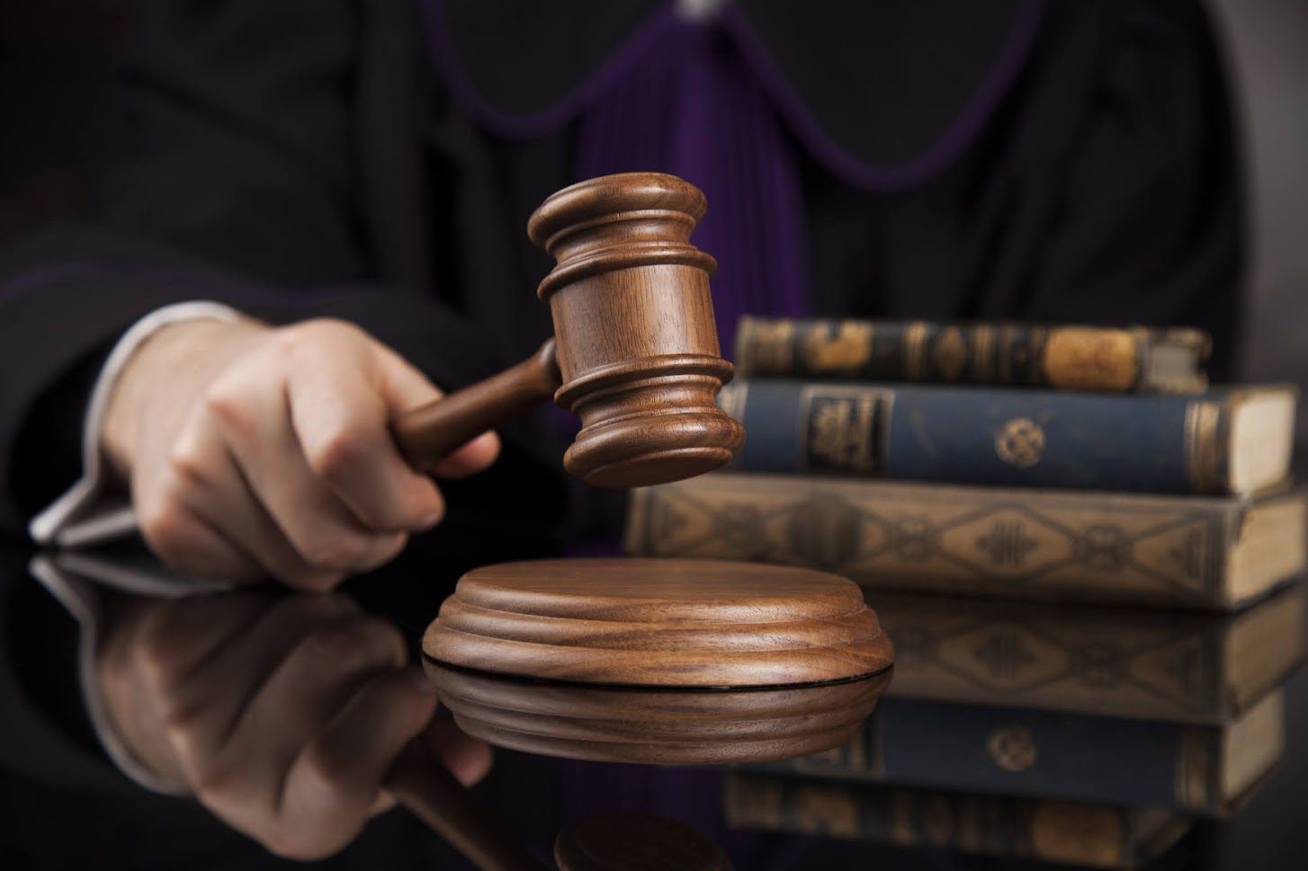 Judge holding gavel with law books