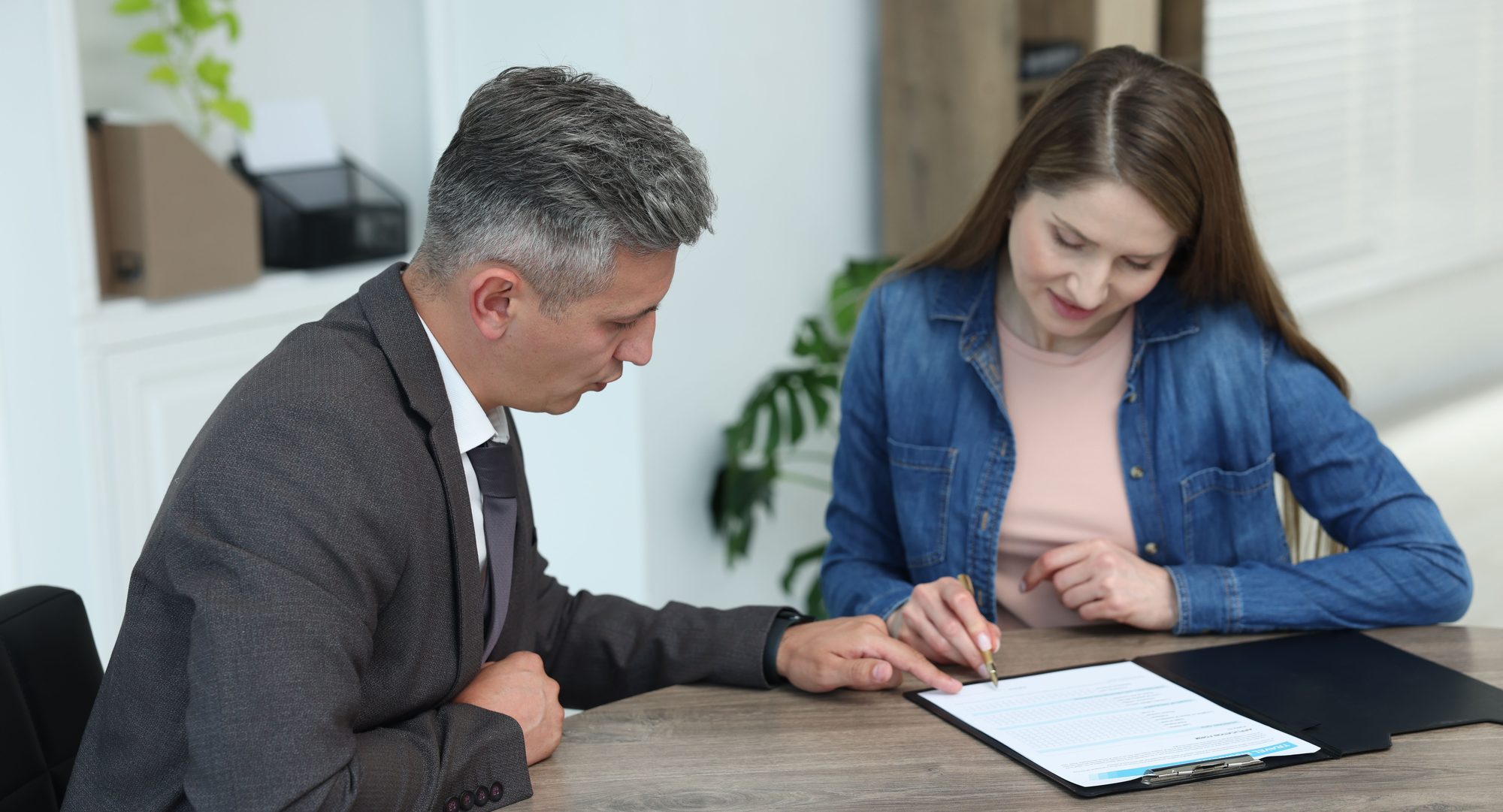 Bail bond agent reviewing paperwork with a client beside a gavel