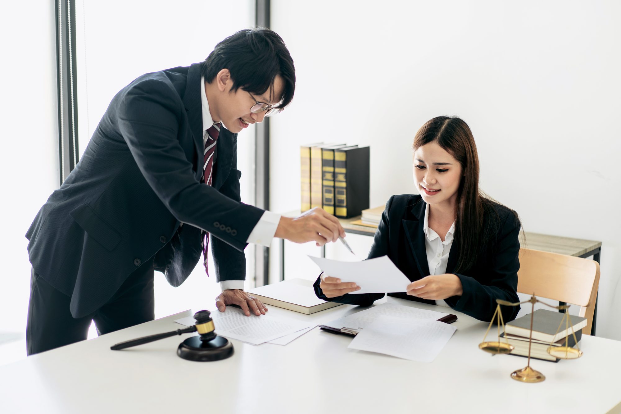 Bail bond agent reviewing paperwork with a client beside a gavel