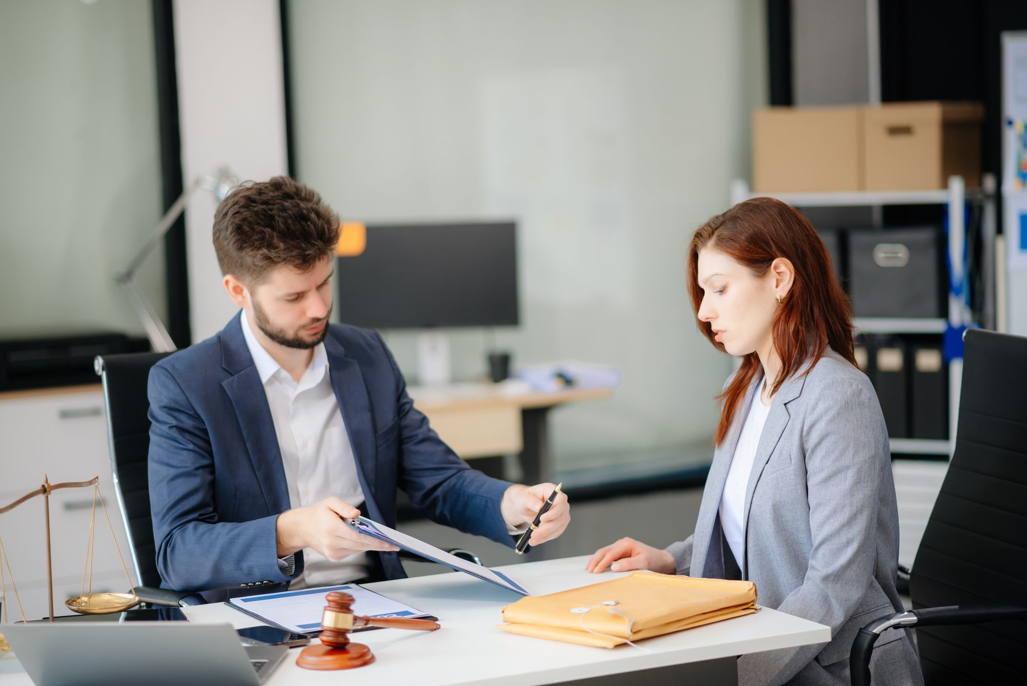 Bail bond agent reviewing paperwork with a client beside a gavel