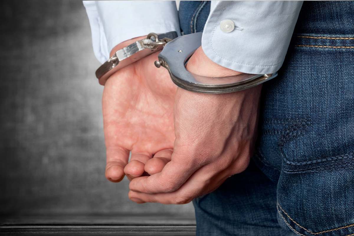 Close-up of a man's hands in handcuffs after a theft arrest